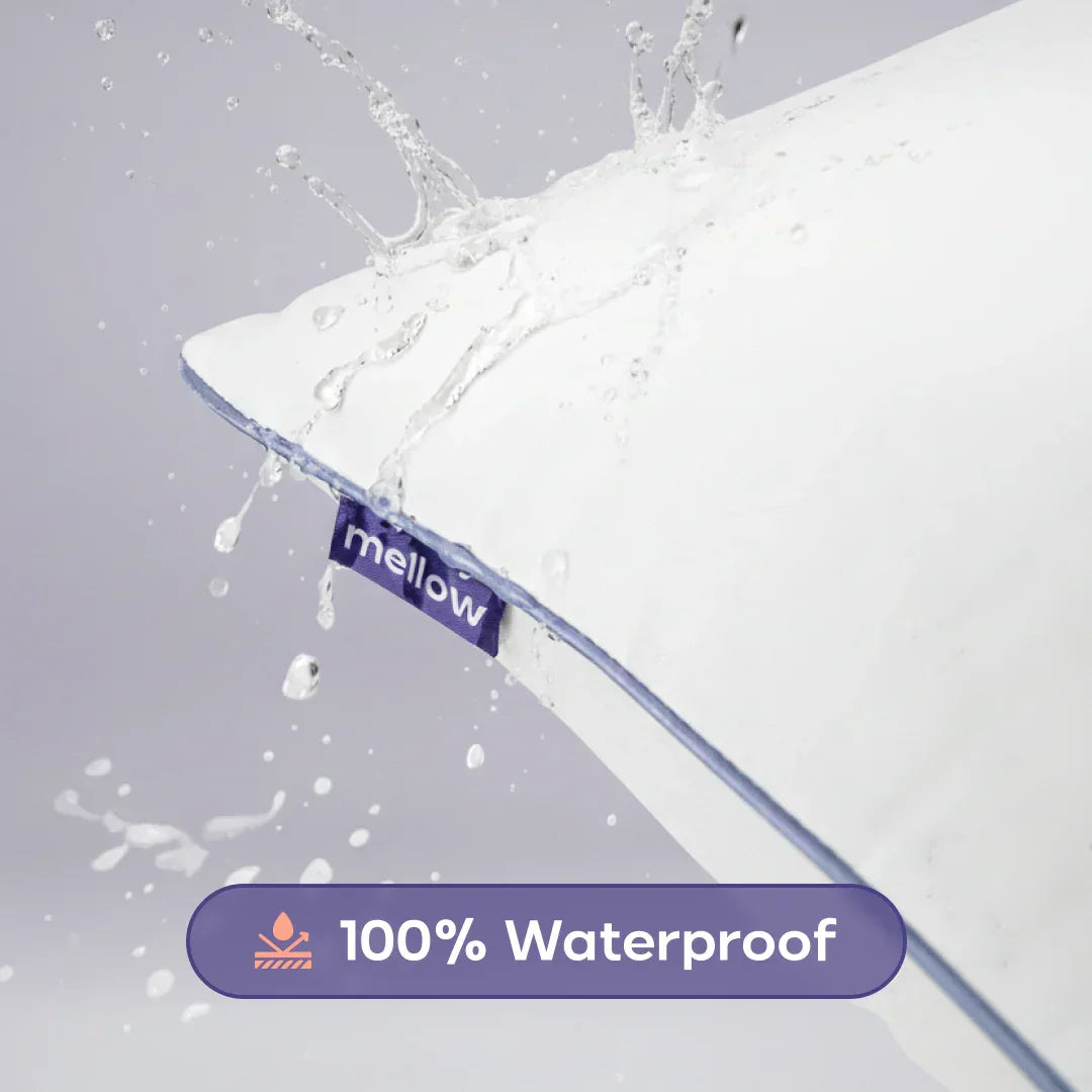 Water splashing on a white waterproof pillow with blue trim and mellow tag
